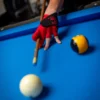 Black Kaine Cues signature shooting glove displaying the red logo on the back of the hand.