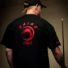 Close-up of the brand logo printed on the front of the black Kaine Cues t-shirt.