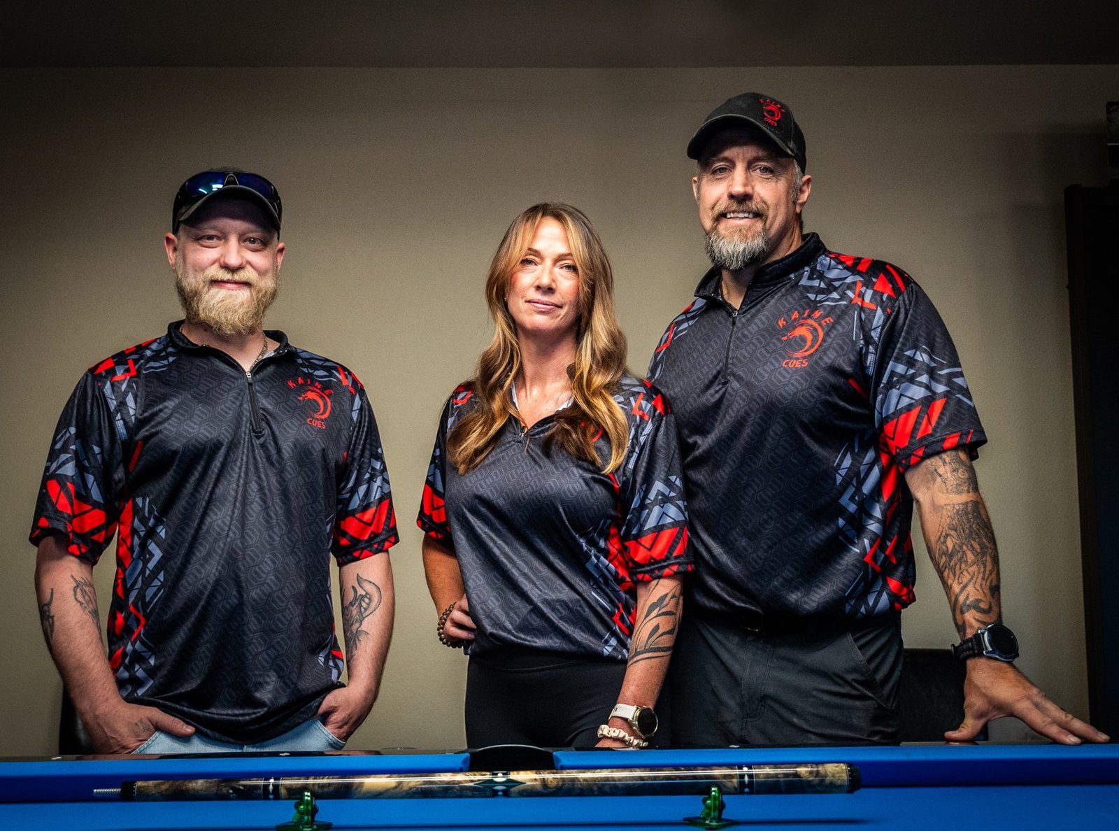 Charcoal gray custom pool cues shooting jersey with red accents and front logo.